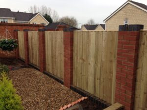 Close board panels set between brick pillars