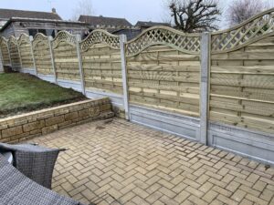 Fancy fence panels set in smooth white posts and gravel boards